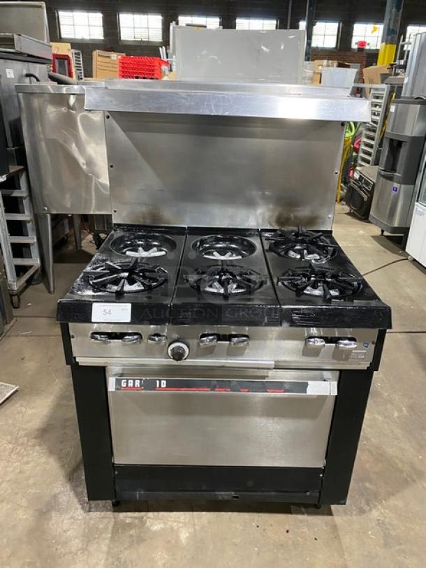 Garland stainless steel 6-burner gas range/oven combo with backsplash, overhead salamander shelf, and wired oven rack; on legs.