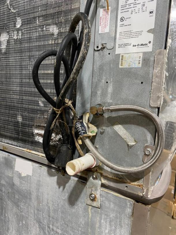 Ice-O-Matic CIM1136HA4 ice machine showing power cables, metal tubing, and manufacturer's label; condition appears used.