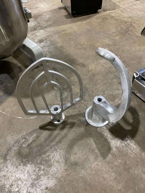 Centaur MAC20 mixer attachments, including aluminum flat beater and spiral dough hook, on a concrete floor.