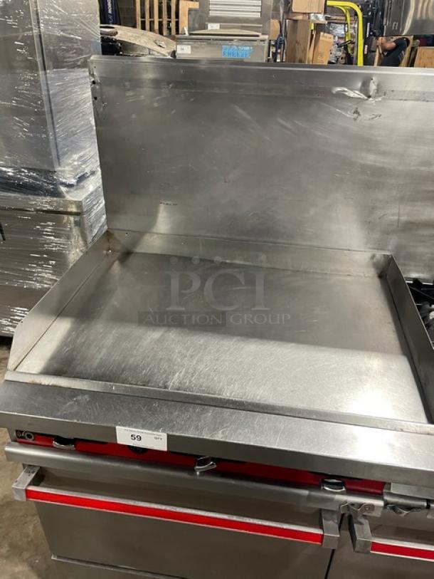 Vulcan commercial stainless steel flat griddle and 4-burner range with double oven combo, back splash, wired oven rack, on legs.