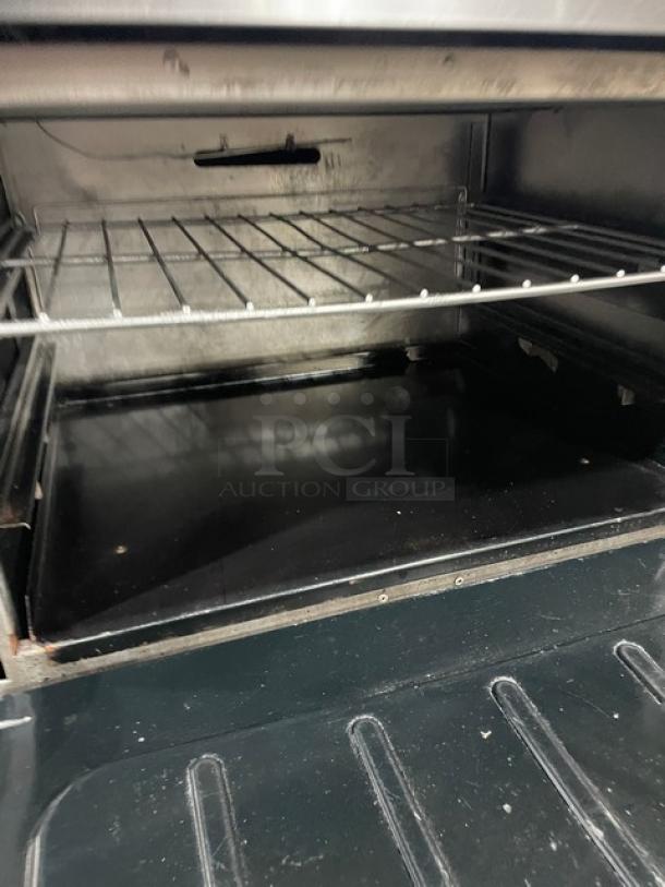 Vulcan commercial stainless steel oven interior with wire rack, part of a griddle and burner range combo.