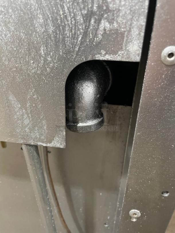 Vulcan stainless steel griddle/range back view showing wiring and connections; visible elbow joint.