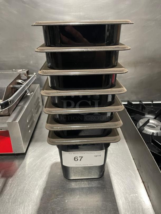 Cambro black commercial food pans stacked, new condition, label showing auction lot 67 for quantity.