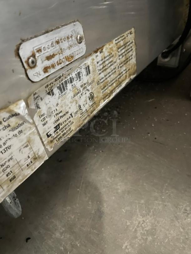 WoodStone stainless steel natural gas split top plancha griddle, model WSPL48364CT, with back and side splash, on legs. Labels visible.