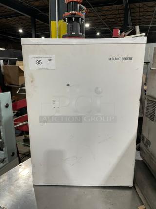 Black & Decker BCFA27 white commercial refrigerator with upper freezer, poly-coated wired rack, visible cosmetic wear.