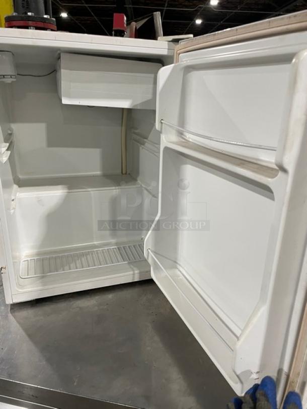 Black & Decker BCFA27 commercial white free-standing fridge with upper freezer, poly coated wired rack, 115V, open door.