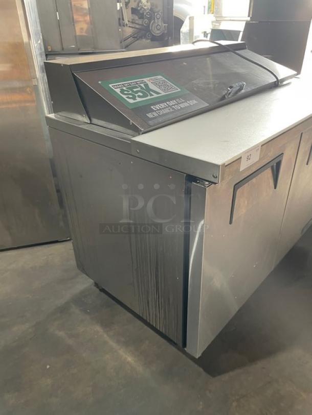 True TSSU-48-12-HC 2-door refrigerated prep table, stainless steel, bain marie style, with cutting board, on casters.