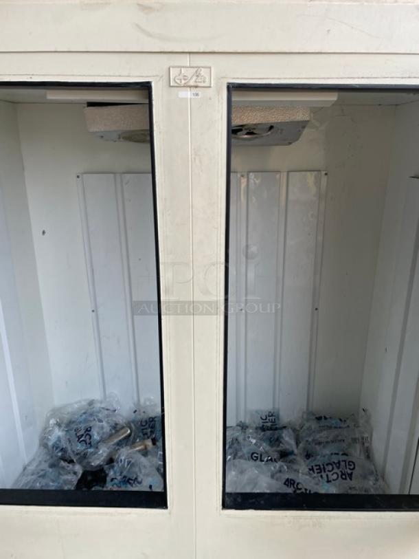 Leer Commercial White Double Glass Swing Door Reach-In Ice Merchandiser, Model IS67AG50, used, showing interior with bags of ice.