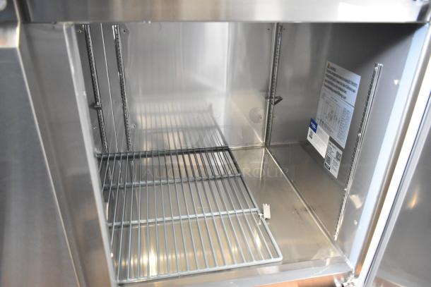 BRAND NEW 2024 Avantco 178SSPPT3 stainless pizza prep table, 115V, 1 phase, interior view with shelf and specs label.
