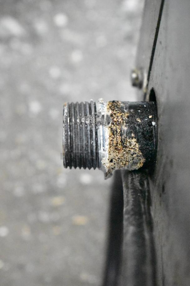 Close-up of a worn connector on a Vollrath stainless steel commercial countertop gas charbroiler grill. Signs of corrosion.