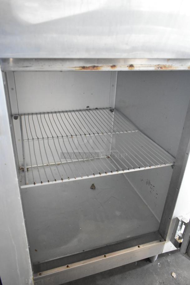 Traulsen G12000 stainless steel commercial freezer, two half-size doors, poly-coated racks, 115V, 1 phase, fair condition.