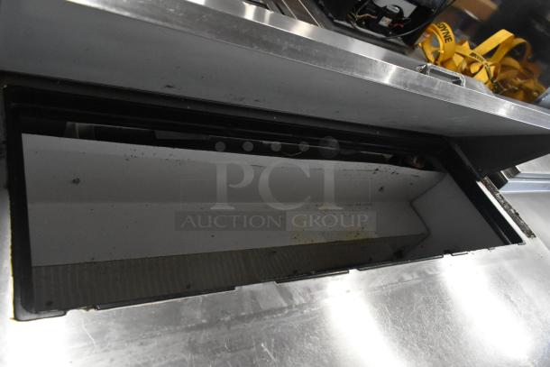 True TSSU-48-12 stainless steel prep table with open top, showing interior. Model and make visible, on commercial casters.