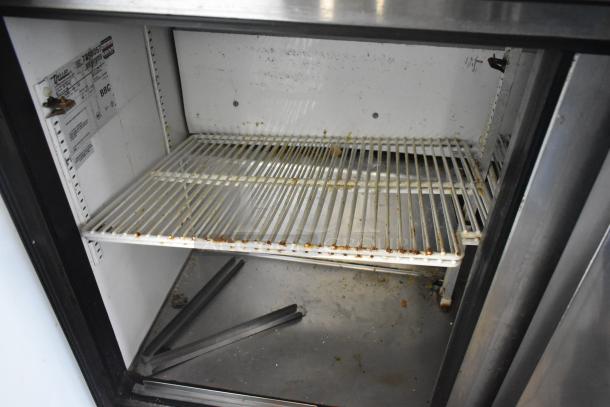 True TSSU-48-12 sandwich salad prep table, stainless steel, interior view showing shelving and True manufacturer label.