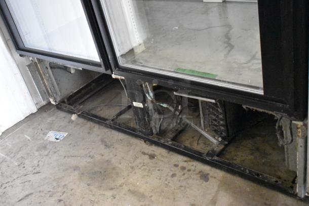 True GDM-49 metal commercial 2-door cooler merchandiser, used, with visible internal wiring and compartments, model tag present.