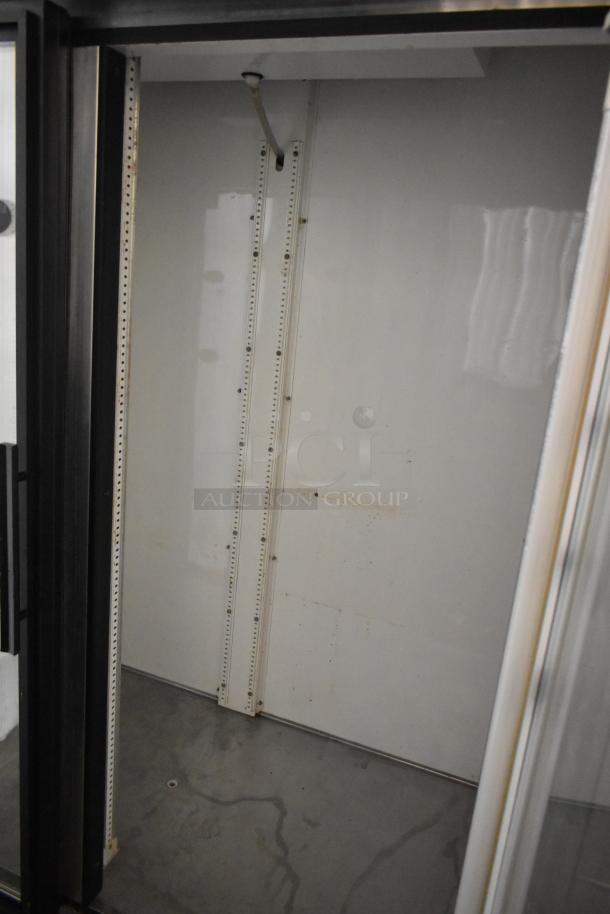 True GDM-49 commercial 2-door cooler interior. Metal shelves, white walls, visible wear. 115V, 1 phase.