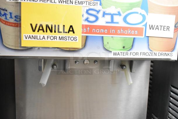 APW Wyott FC-14D stainless steel beverage dispenser, countertop model, 120 volts, 1 phase, vanilla and water labels visible.