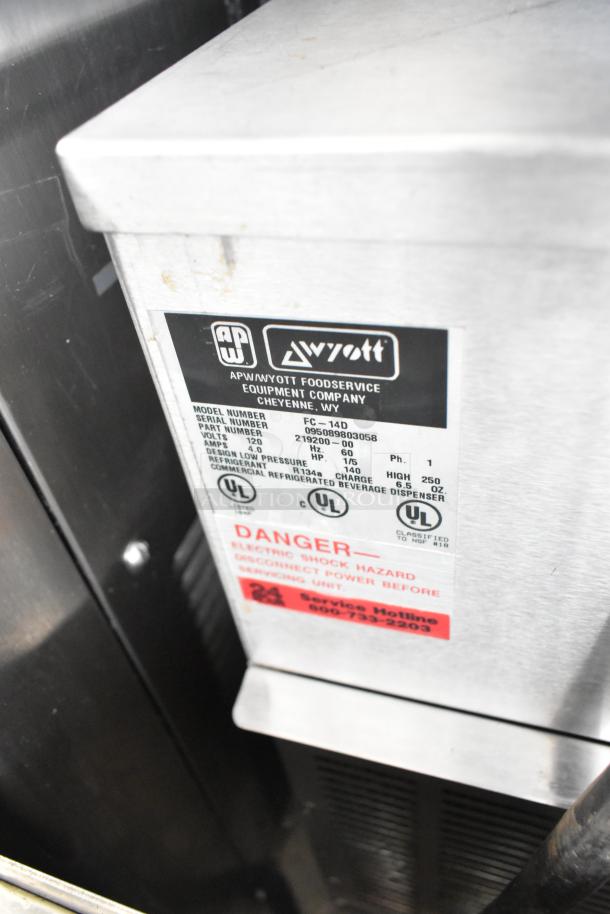 APW Wyott FC-14D stainless steel beverage dispenser, commercial countertop model, 120V, 1 phase. Label with model details visible.