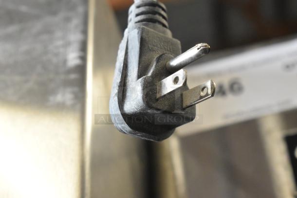 Close-up of the power plug on a Traulsen RHT132WPTHHG stainless steel refrigerator, showcasing connector prongs.