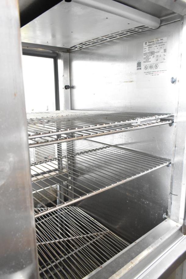 Traulsen RHT132WPTHHG commercial refrigerator, stainless steel, 2 half doors, interior shelving, 115V, merchandiser label shown.