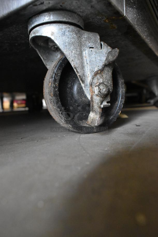 Traulsen commercial cooler caster, steel frame, showing wear. Part of 2 half-size door reach-in cooler. 115 Volts, 1 Phase.