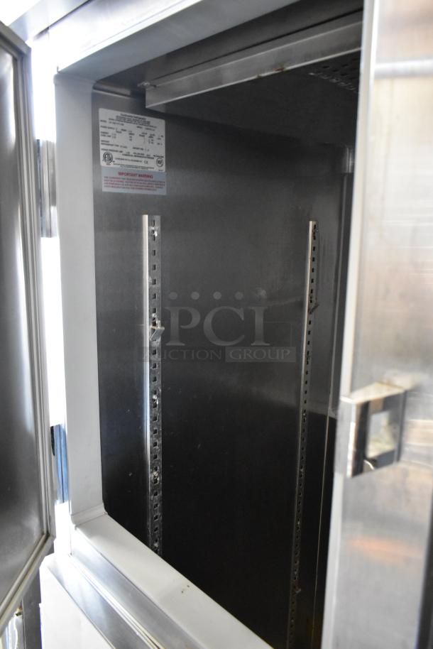 Traulsen stainless steel commercial cooler with 2 half-size doors, on casters. 115 volts, 1 phase. Interior label visible.