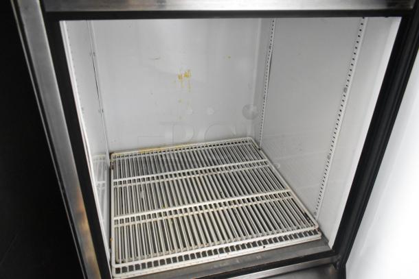 True T-23-2 stainless steel reach-in cooler with two half-size doors, commercial casters, 115V, shows interior wear.