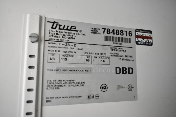 True T-23-2 stainless steel reach-in cooler label, showing model, voltage (115 volts), and refrigerant info. Made in USA.