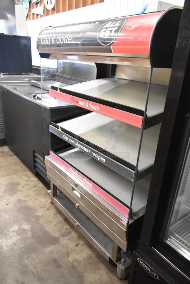 Metal commercial floor-style reach-in warming display case merchandiser, features multiple shelves and bright signage labels.