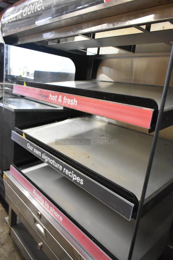 Metal commercial reach-in warming display case with multiple shelves, featuring "hot & fresh" and "ready to share" labels.