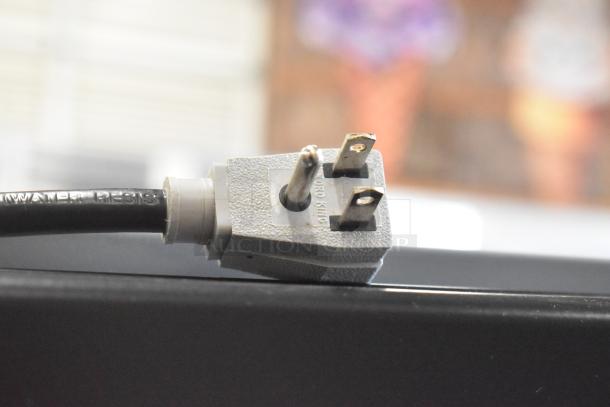 Close-up of a three-prong plug for the 2022 True GDM-41SL-60-HC-LD mini cooler, showing "CORD KING" label.