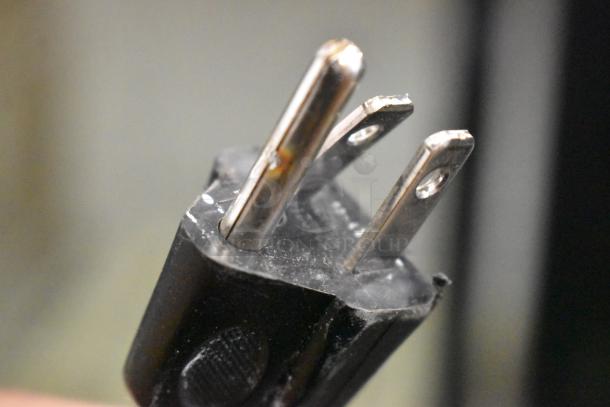 Close-up of a power plug for the IDW G-12-F334B-HC mini cooler, showing prongs in good condition.