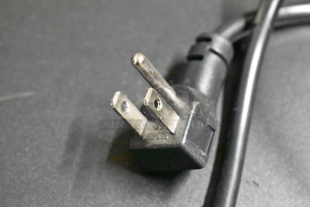 Close-up of a power plug for a Frigidaire EFMIS9000 mini cooler. Features two flat prongs and one round grounding prong.