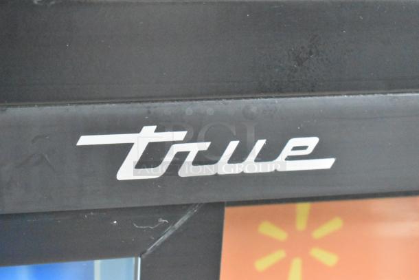 Close-up of the "True" logo on the 2019 GDM-41SL-48-HC-LD metal two-door reach-in cooler merchandiser.