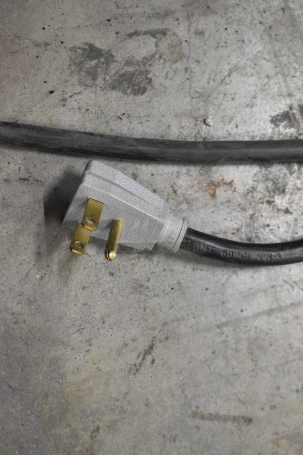 2019 True GDM-41SL-48-HC-LD cooler plug and cord on textured floor. 115V, 1 Phase. Metal finish, poly coated racks.