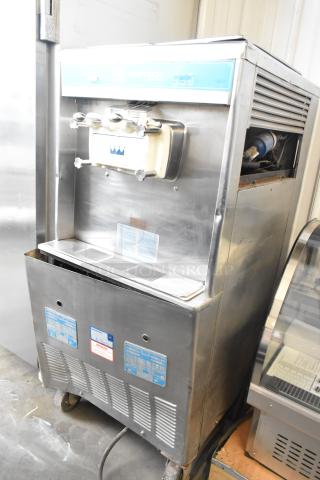 Taylor 754-27 stainless steel soft serve ice cream machine, 2 flavors with twist, on commercial casters, 208-230V, 1 phase.