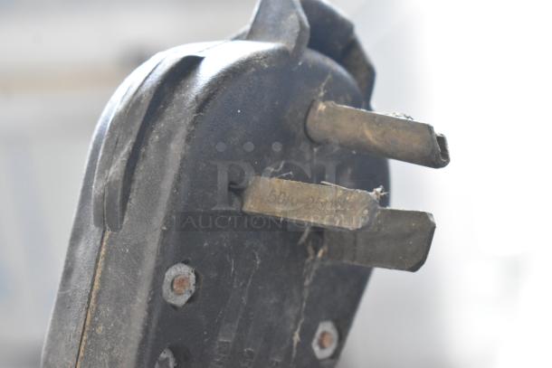 Close-up of a power plug for a Taylor 754-27 soft serve ice cream machine, showing prongs and voltage markings.