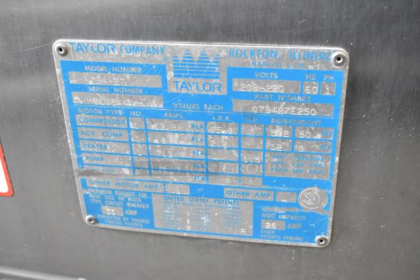 Taylor 754-27 stainless steel 2-flavor soft serve ice cream machine; model tag shows 208-230 volts, 1 phase, on casters.