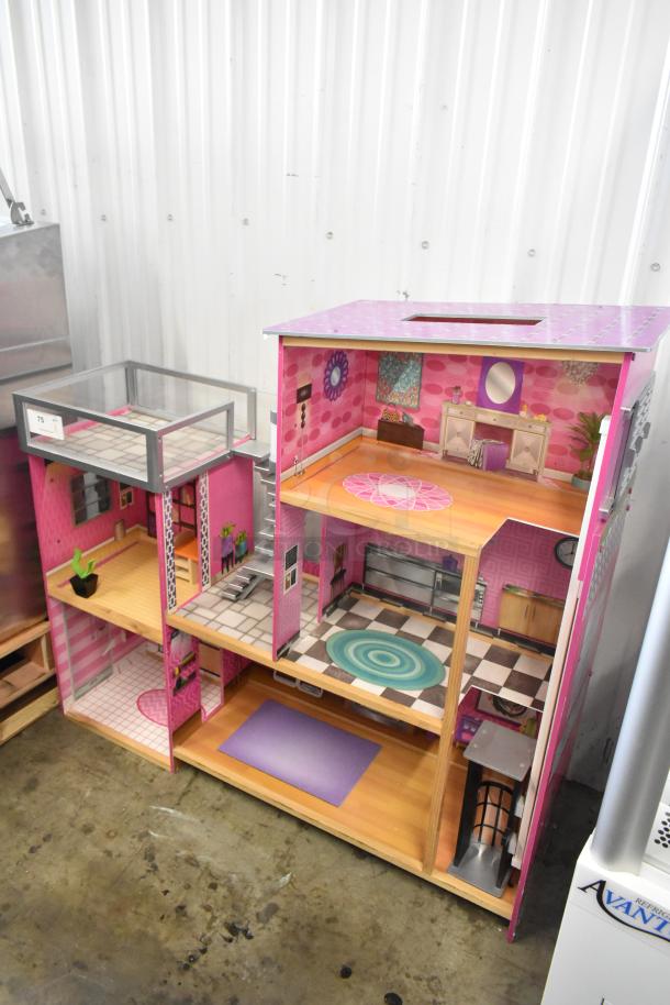Colorful multi-level doll playhouse with detailed rooms, staircase, and balcony. Good condition, number 75 label visible.