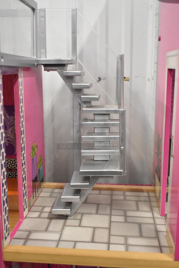 Doll playhouse interior with pink walls, metal staircase, and patterned flooring, in good condition.