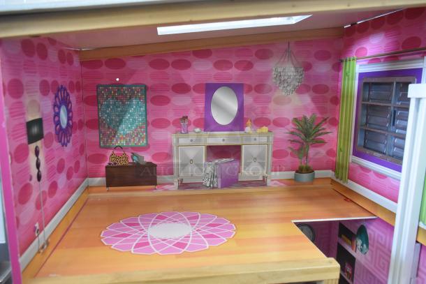 Doll playhouse with vibrant pink walls, modern furniture, decorative mirror, and plants. Well-maintained interior rooms.