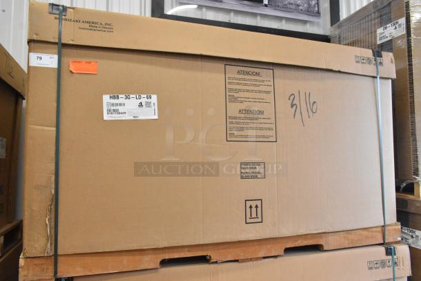 Brand new Hoshizaki HBB-3G-LD-69 cooler in box. Features 2 doors, metal construction, 115V, 1 phase. Model info visible.