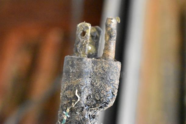 Rusted plug with visible damage, frayed wires, and worn insulation, indicating poor condition and potential safety hazards.