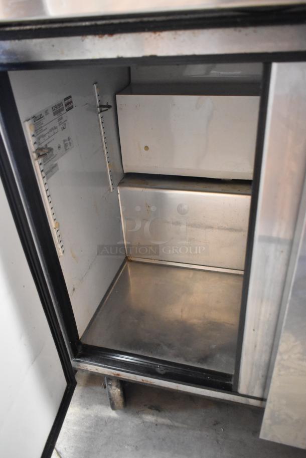 True TUC-36 stainless steel 2-door undercounter cooler, interior view, visible shelving slots, on commercial casters.