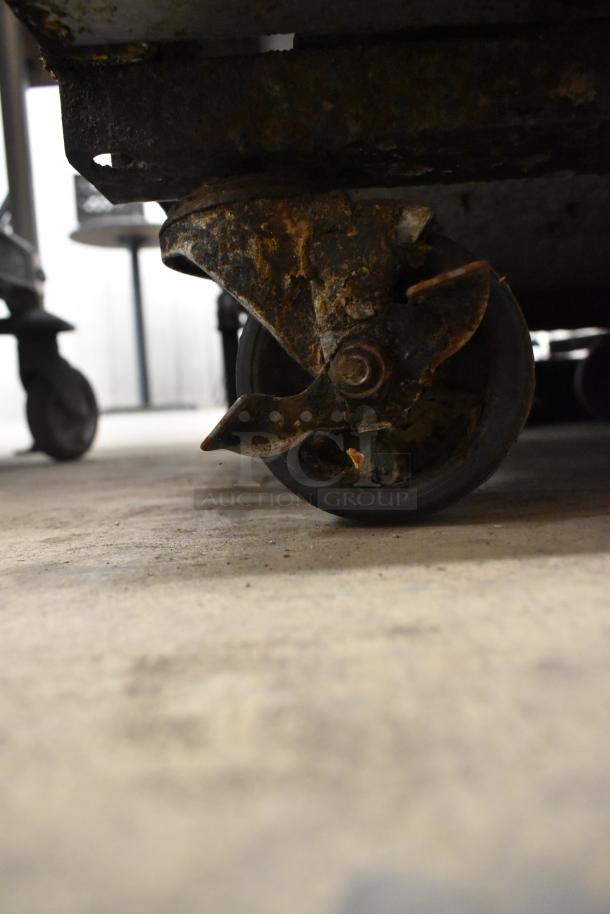 Close-up of a commercial caster wheel with visible rust and wear on a Turbo Air TSR-23SD cooler.