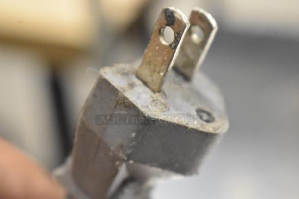 Close-up of a slightly worn electrical plug, likely from the Turbo Air TSR-23SD commercial refrigerator, showing detail of prongs.