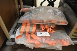 Lot of orange straps in plastic bags, labeled "98 QTY 1 lot," minimal visible wear, stored on a metal cart.