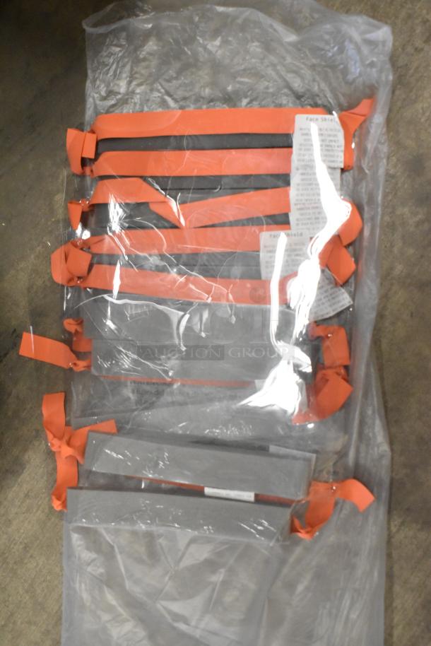 Lot of face shields with red straps in clear packaging. Labels indicate shield specifications and use instructions. New condition.