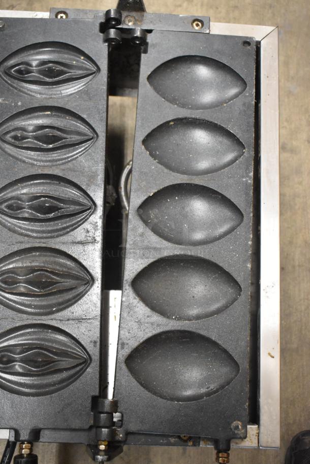 NP-257 Stainless Steel Commercial Waffle Maker, open view. Features patterned molds, uses 110 volts, 1 phase. Used condition.