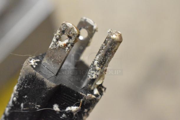 Close-up of a worn power plug for a PYY PYYHFLFY-233SRUS waffle maker, showing corrosion and residue on metal prongs.