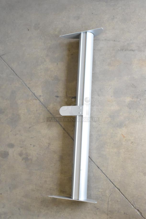 Silver roll-up sign base featuring a sturdy metal frame, flat base, and retractable mechanism. Appears to be in good condition.